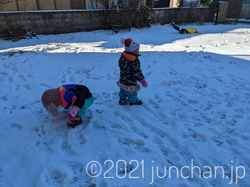 庭の雪で遊ぶ子どもたち