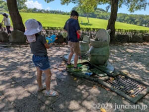 東御中央公園 水鉄砲に給水する息子を打ち濡らす長女